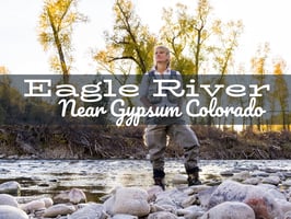 Fly angler casting on the Eagle River near Vail with autumn trees and clear water in the background.