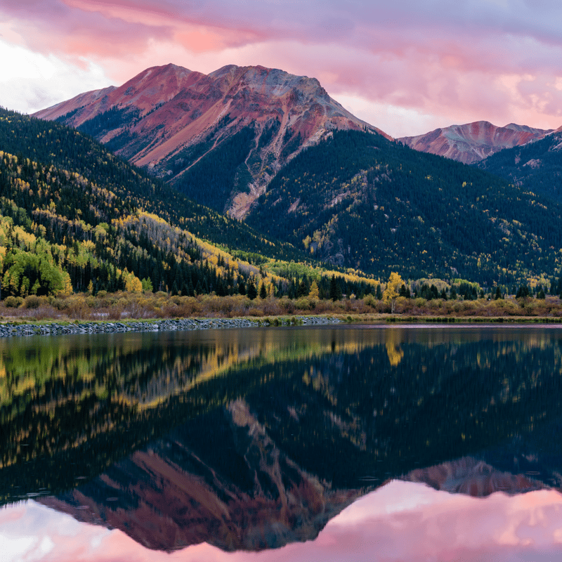 Scenic panorama of the Piedra River valley in southern Colorado, showing clear mountain water and rocky banks where anglers chase brown and rainbow trout