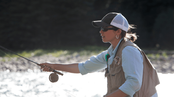 Close-up of pockets on a fly fishing vest filled with flies and tools.