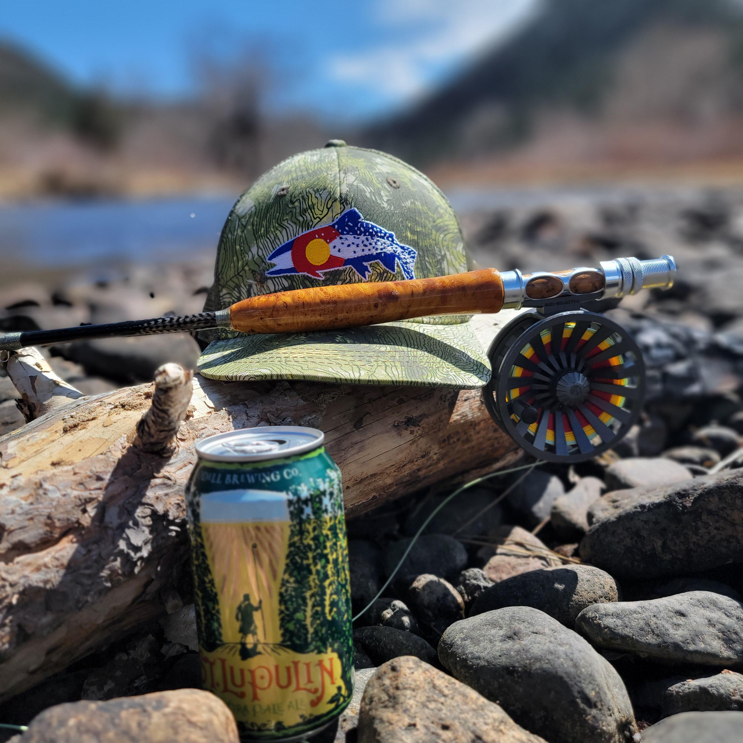 rise beyond fly rod, odells st lupin beer and a rep your water hat all laid on the shore of the south platte river