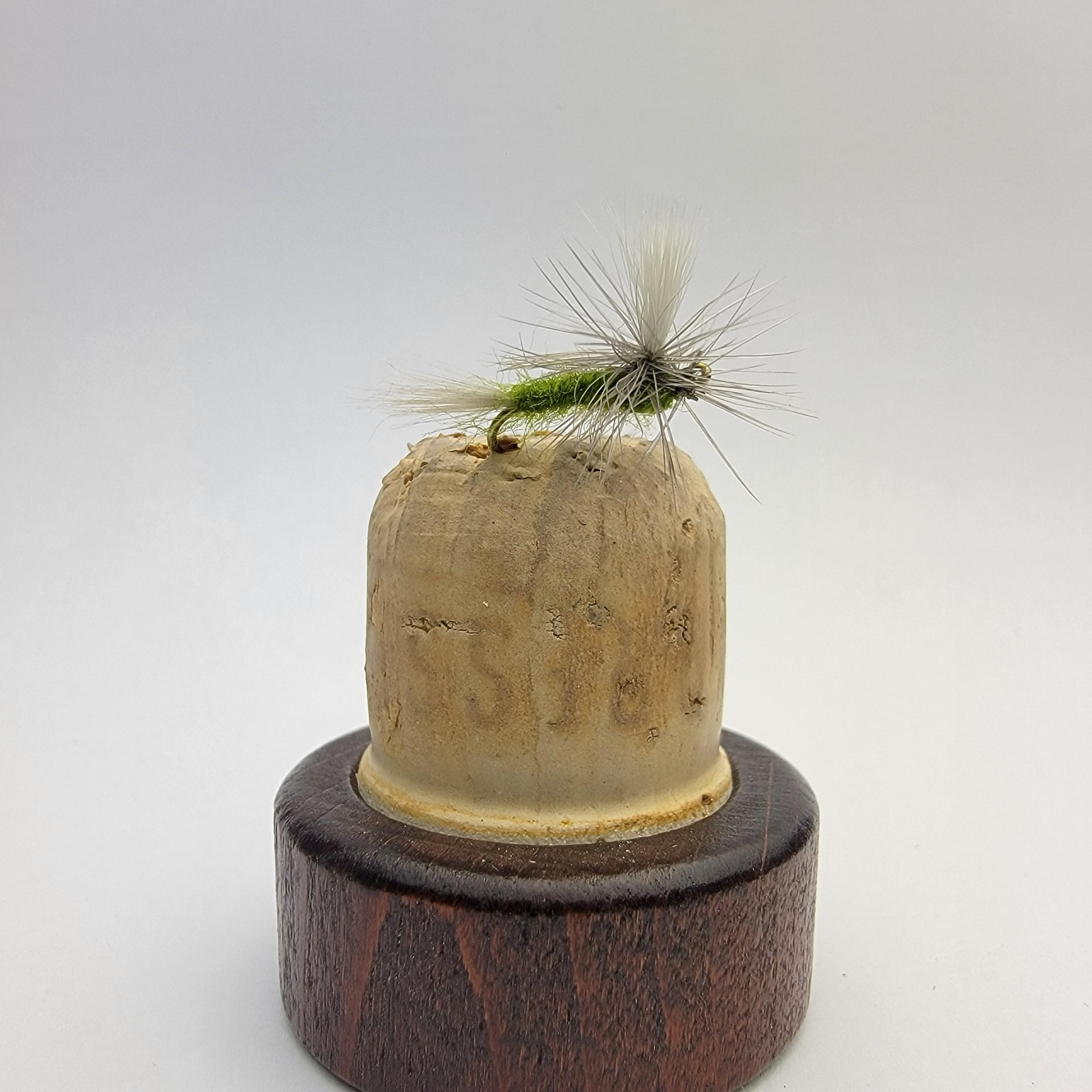 Blue-Winged Olive Fly Hatch in Colorado: A close-up of a Parachute Adams fly resting on a fishing line, with a calm Colorado river and golden fall leaves in the background